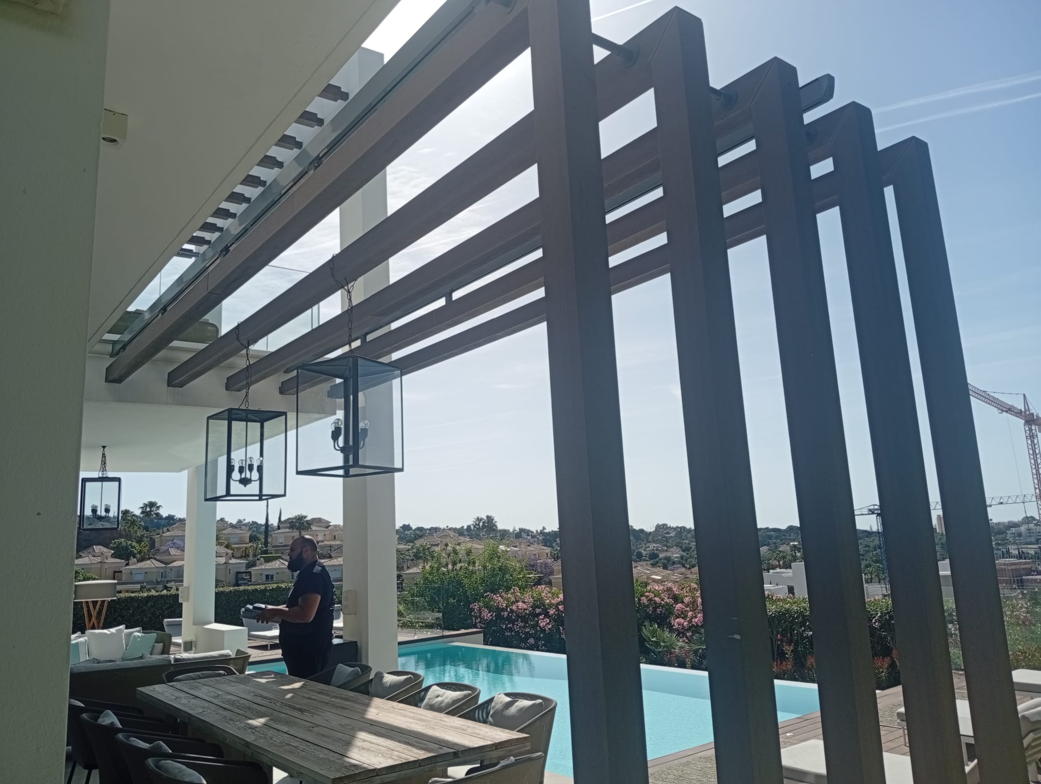 Pérgola de aluminio con techo de cristal y lamas decorativas
